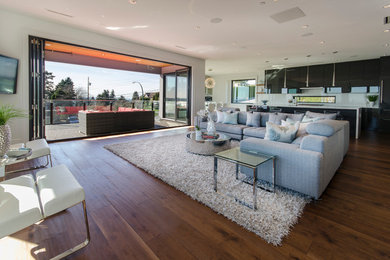 Inspiration for a large modern open concept medium tone wood floor living room remodel in Vancouver with white walls and a wall-mounted tv