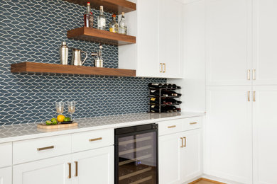 Inspiration for a mid-sized contemporary u-shaped light wood floor and brown floor eat-in kitchen remodel in Portland with blue backsplash, white countertops, an undermount sink, shaker cabinets, white cabinets, quartz countertops, glass tile backsplash, paneled appliances and an island