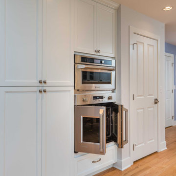 Modern Kitchen with White Flat Panel Shaker Cabinets & Natural Stone Backsplash