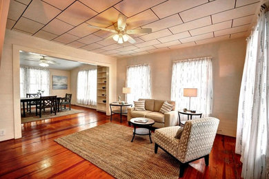 Living room - large coastal open concept medium tone wood floor and brown floor living room idea in Miami with gray walls and no fireplace
