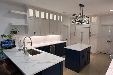 Example of an arts and crafts l-shaped cement tile floor and beige floor eat-in kitchen design in Dallas with an undermount sink, shaker cabinets, blue cabinets, quartz countertops, white backsplash, quartz backsplash, an island and white countertops
