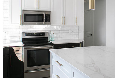 This is an example of a mid-sized transitional l-shaped eat-in kitchen in Edmonton with an undermount sink, shaker cabinets, white cabinets, quartz benchtops, white splashback, subway tile splashback, stainless steel appliances, vinyl floors, with island, brown floor and white benchtop.