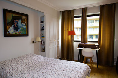 Foto de dormitorio principal clásico de tamaño medio sin chimenea con paredes blancas, suelo de madera clara y suelo marrón