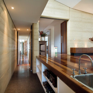 Immagine di un piccolo ingresso o corridoio minimalista con pareti gialle e pavimento in cemento