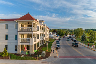 Mid-sized beach style white three-story wood apartment exterior photo in Other with a shed roof and a shingle roof