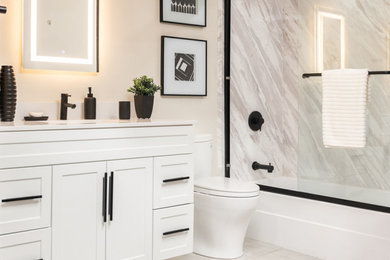 Mid-sized trendy stone slab vinyl floor bathroom photo in Columbus with a one-piece toilet, beige walls, a drop-in sink, granite countertops and white countertops
