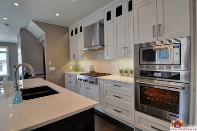 Mid-sized trendy l-shaped dark wood floor eat-in kitchen photo in Calgary with a drop-in sink, recessed-panel cabinets, white cabinets, granite countertops, beige backsplash, ceramic backsplash, stainless steel appliances and an island