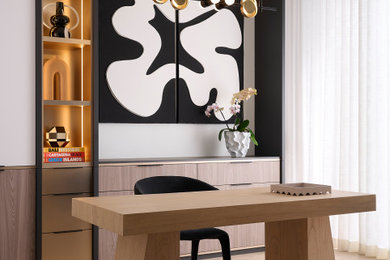 Diseño de despacho minimalista grande con paredes blancas, suelo de madera clara y escritorio independiente