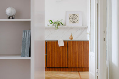 Imagen de cocina lineal contemporánea abierta con fregadero bajoencimera, puertas de armario de madera en tonos medios, encimera de acrílico y suelo de madera clara