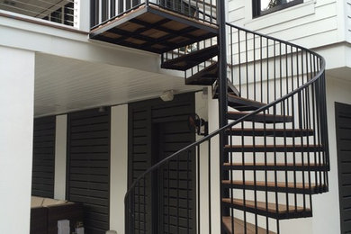 Large trendy wooden spiral staircase photo in Charleston with wooden risers