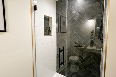 Example of a mid-sized trendy 3/4 ceramic tile terra-cotta tile, black floor and single-sink corner shower design in New York with shaker cabinets, beige cabinets, a one-piece toilet, white walls, an integrated sink, quartz countertops, a hinged shower door, white countertops and a freestanding vanity