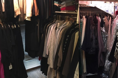 Small elegant women's light wood floor walk-in closet photo in Chicago with white cabinets
