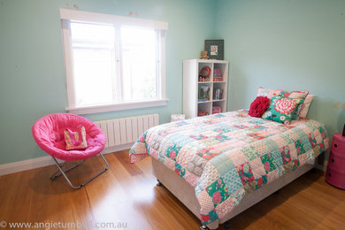 This is an example of a mid-sized contemporary kids' bedroom for girls in Sydney with blue walls and medium hardwood floors.