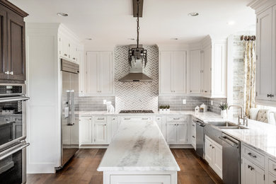 Large contemporary u-shaped separate kitchen in Philadelphia with a farmhouse sink, shaker cabinets, white cabinets, marble benchtops, grey splashback, subway tile splashback, stainless steel appliances, dark hardwood floors, with island and brown floor.