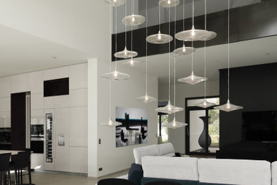 Cette image montre une grande salle à manger ouverte sur la cuisine design avec une cheminée standard, un manteau de cheminée en pierre, un mur blanc, un sol en carrelage de céramique et un sol gris.