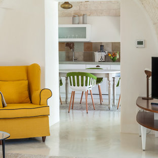 Foto de salón para visitas mediterráneo, grande, con suelo de cemento y televisor independiente