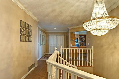 Hallway - medium tone wood floor hallway idea in Vancouver with beige walls
