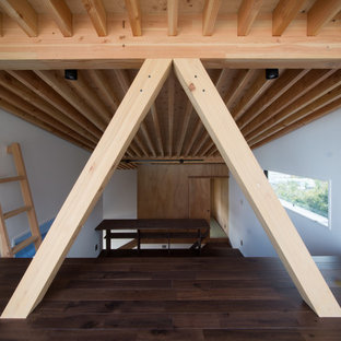 Immagine di una camera da letto stile loft etnica di medie dimensioni con pareti blu, parquet scuro, stufa a legna, cornice del camino in cemento e pavimento marrone