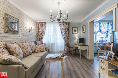 Mittelgroßes, Offenes Mediterranes Wohnzimmer mit blauer Wandfarbe, braunem Holzboden und freistehendem TV in Sankt Petersburg