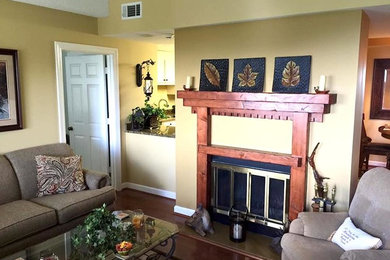 Photo of a mid-sized arts and crafts formal enclosed living room in Charlotte with beige walls, dark hardwood floors, a standard fireplace, a wood fireplace surround and no tv.