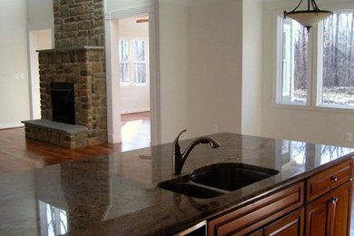 Example of a classic medium tone wood floor eat-in kitchen design in DC Metro with a double-bowl sink, medium tone wood cabinets, an island and raised-panel cabinets