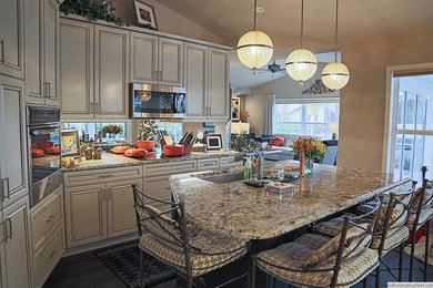 Elegant laminate floor kitchen photo in Other with an undermount sink, granite countertops, stainless steel appliances and an island