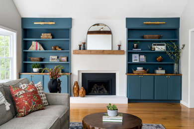 Living room - transitional medium tone wood floor, brown floor and vaulted ceiling living room idea in Boston with white walls and a standard fireplace