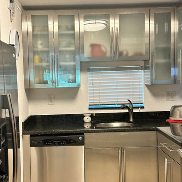 Stainless Steel Kitchen Cabinetry with Glass Upper Doors
