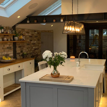 Light grey kitchen with large island and integrated sink and wine fridge
