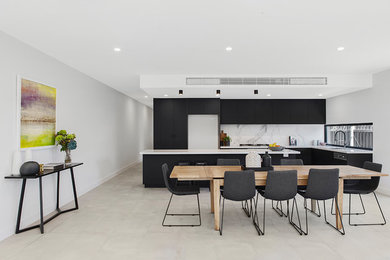 Inspiration for a large contemporary galley open plan kitchen in Melbourne with an undermount sink, black cabinets, quartz benchtops, white splashback, porcelain splashback, stainless steel appliances, porcelain floors, with island, grey floor and white benchtop.