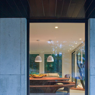 Стильный дизайн: большая гостиная-столовая в современном стиле с белыми стенами и бетонным полом - последний тренд