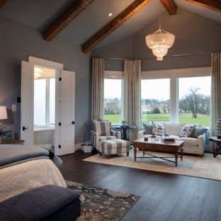 Inspiration for a large country master bedroom in Dallas with blue walls, medium hardwood floors, a standard fireplace, a concrete fireplace surround and brown floor.