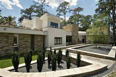 Example of a trendy two-story flat roof design in Houston