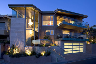 Photo of a contemporary three-storey exterior in Los Angeles with mixed siding and a flat roof.