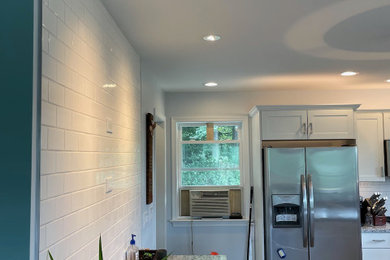 Inspiration for a mid-sized 1960s eat-in kitchen remodel in Baltimore with shaker cabinets, white cabinets, granite countertops and an island