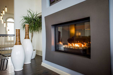 Living room - large contemporary open concept dark wood floor living room idea in Other with blue walls, a plaster fireplace and a concealed tv
