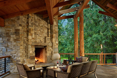 Example of a mountain style deck design in Seattle with a roof extension and a fireplace