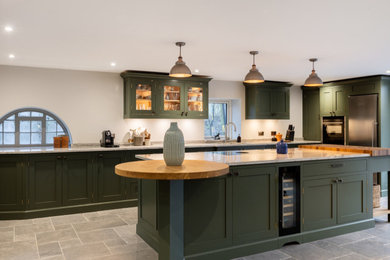 Offene, Große Landhaus Küche in L-Form mit Schrankfronten im Shaker-Stil, grünen Schränken, Granit-Arbeitsplatte und Kücheninsel in Sussex