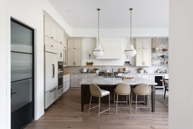 Example of a mid-sized transitional l-shaped medium tone wood floor and brown floor kitchen pantry design in Phoenix with a single-bowl sink, shaker cabinets, beige cabinets, quartzite countertops, beige backsplash, stone slab backsplash, stainless steel appliances and beige countertops