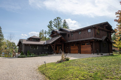Imagen de fachada de casa marrón y marrón rústica de tamaño medio de dos plantas con revestimientos combinados, tejado a dos aguas y tejado de teja de madera