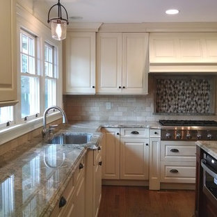 Design ideas for a large transitional u-shaped kitchen pantry in New York with an undermount sink, raised-panel cabinets, beige cabinets, granite benchtops, beige splashback, subway tile splashback, white appliances, dark hardwood floors and with island.