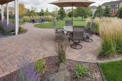 Design ideas for a mid-sized arts and crafts backyard patio in Minneapolis with concrete pavers.
