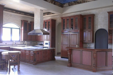 Example of a huge classic u-shaped marble floor and beige floor eat-in kitchen design in Phoenix with a farmhouse sink, raised-panel cabinets, marble countertops, multicolored backsplash, limestone backsplash, paneled appliances and an island