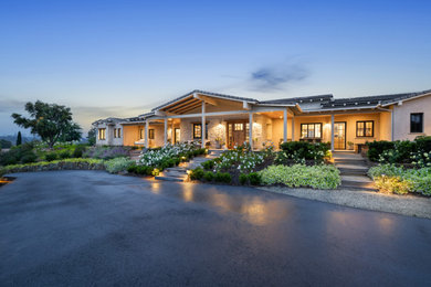 Huge 1960s beige one-story stone and board and batten exterior home idea in San Diego with a tile roof and a gray roof