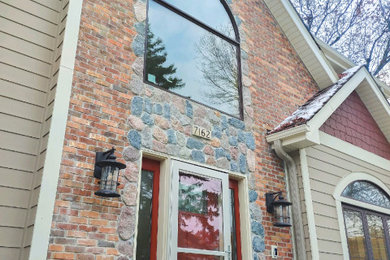 Example of a large classic beige two-story stone house exterior design in Minneapolis