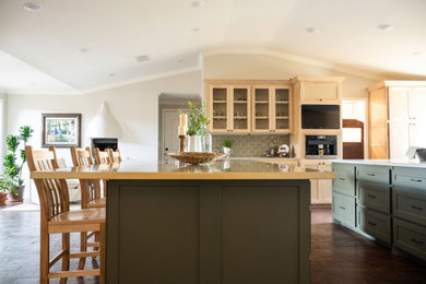 Example of a huge u-shaped brick floor, red floor and vaulted ceiling open concept kitchen design in Other with shaker cabinets, quartzite countertops, green backsplash, stainless steel appliances, two islands, beige countertops, an undermount sink and subway tile backsplash