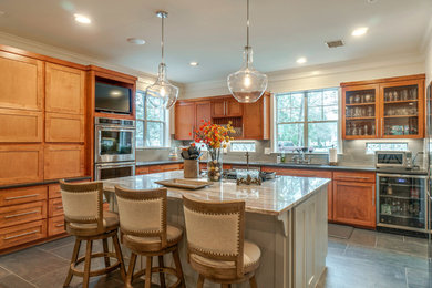 Open concept kitchen - large transitional gray floor open concept kitchen idea in Houston with a drop-in sink, shaker cabinets, medium tone wood cabinets, gray backsplash, porcelain backsplash, stainless steel appliances and an island