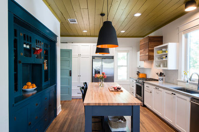 Inspiration for a transitional medium tone wood floor enclosed kitchen remodel in Austin with an undermount sink, shaker cabinets, white cabinets, gray backsplash, stainless steel appliances, an island and gray countertops