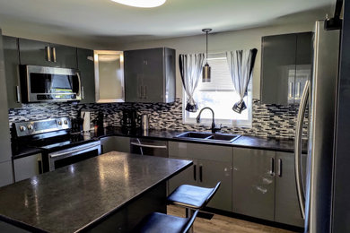 Inspiration for a mid-sized modern u-shaped enclosed kitchen remodel in Other with flat-panel cabinets, gray cabinets, an island and black countertops