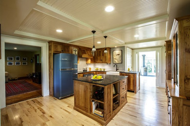 Inspiration for a country light wood floor kitchen remodel in Other with a farmhouse sink, shaker cabinets, medium tone wood cabinets, granite countertops, white backsplash, mosaic tile backsplash, colored appliances and an island